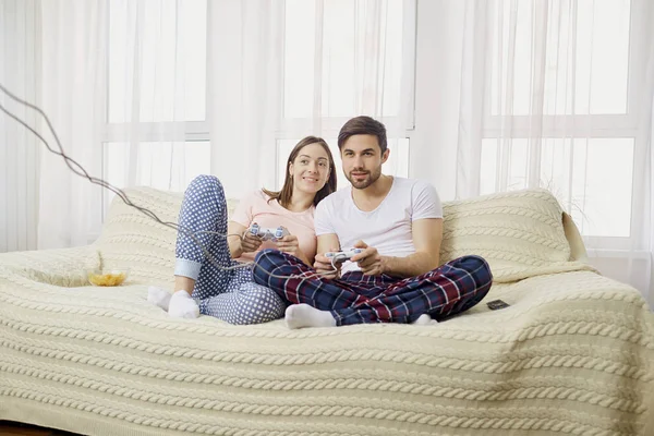 Чоловік і дружина грають у відеоігри з джойстиками в руках в — стокове фото