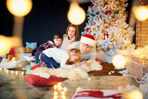 Мати і батько з дітьми, граючи у себе вдома на Різдво — стокове фото