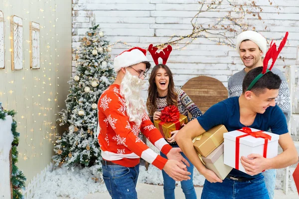 Um grupo de amigos com presentes em uma festa de Natal — Fotografia de Stock