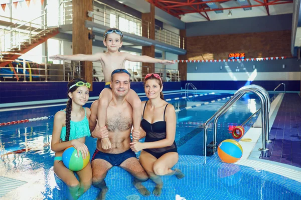 Een gelukkige familie in een zwembad binnen. — Stockfoto