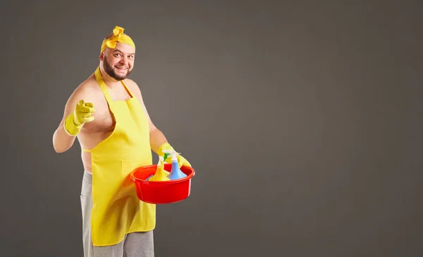 Engraçado homem de limpeza de gordura em um avental na limpeza . — Fotografia de Stock