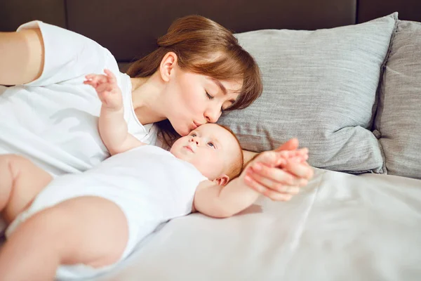 Madre jugando con el bebé en la cama . — Foto de Stock