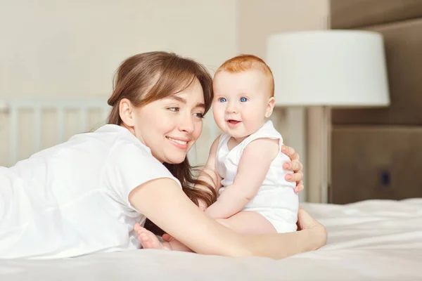 Madre jugando con el bebé en la cama . — Foto de Stock