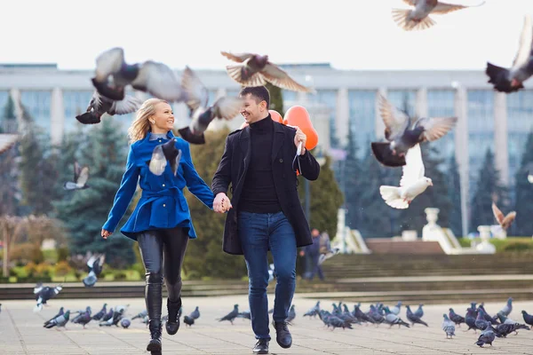 Egy szerető pár egy kabátot léggömbökkel a kőr a kezében — Stock Fotó