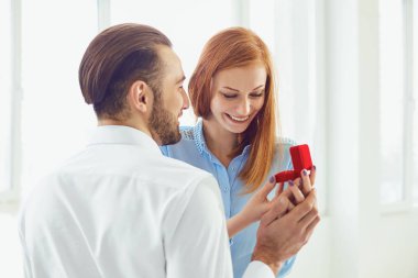 Adam bir kız parlak windows ile bir odada öneriyor.