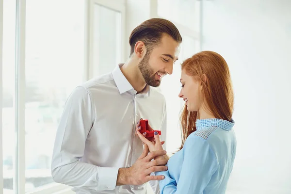 Man proposes to a girl in room with bright windows. — Stock Photo, Image