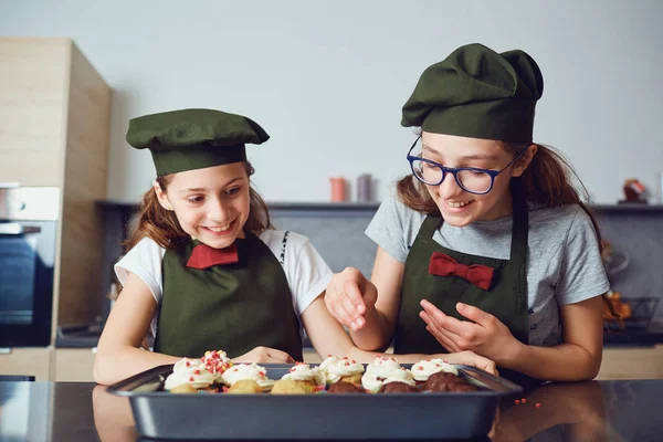 Meninas derramando polvilhas na pastelaria — Fotografia de Stock