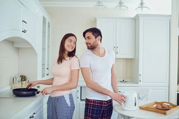 Jovem casal preparando comida na cozinha . — Fotografia de Stock
