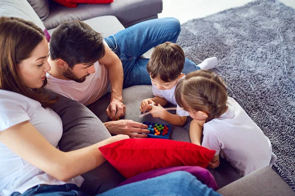 Moeder, vader en kinderen spelen samen. — Stockfoto