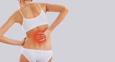 Bir kadın bir acı geri elini tutar.