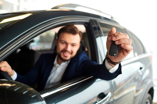 Чоловічий водій посміхається тримає ключі від машини — стокове фото