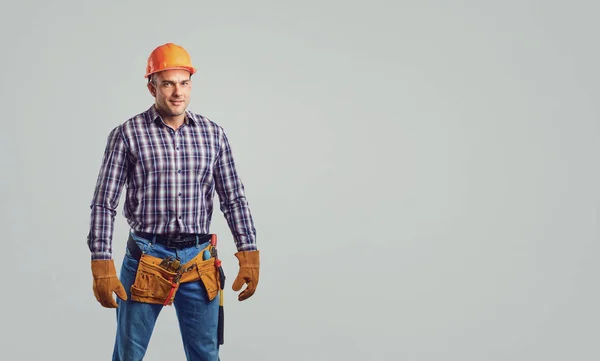 Male builder in  helmet in a plaid shirt smiling — Stock Photo, Image