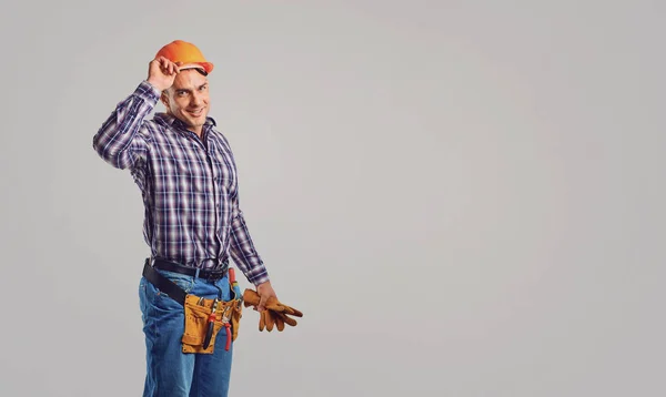 Lächelnder erwachsener Bauunternehmer mit Hut und Gruß — Stockfoto