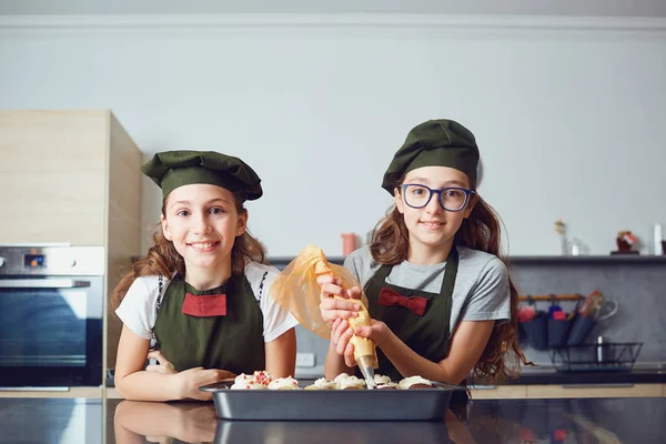 Flickor barn i cook uniformer i köket. — Stockfoto
