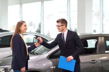 Bir kadın satıcısı otomatik salonda gelen bir araba alıyor