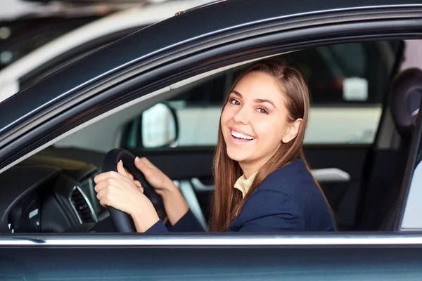 Een vrouwelijke bestuurder glimlacht en houdt van autosleutels. — Stockfoto