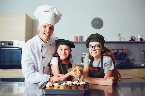 Pastelería-cocinero con niñas niños preparan galletas en la cocina . — Foto de Stock