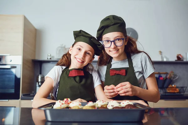 Meninas crianças em uniformes de cozinheiro na cozinha . — Fotografia de Stock