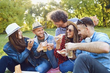 Bir grup genç insan parkta piknik sahip.
