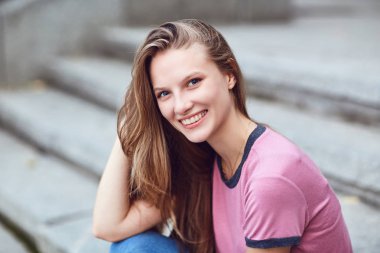 Sarışın mutlu kız gülümsüyor kentsel tarzı. 