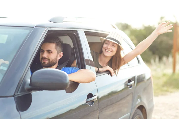 Heureux couple voyageant en voiture sur la route en été — Photo