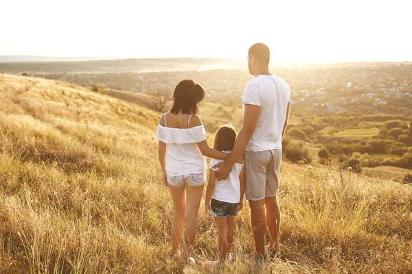 Lycklig familj på natur på sommaren vid solnedgången. — Stockfoto