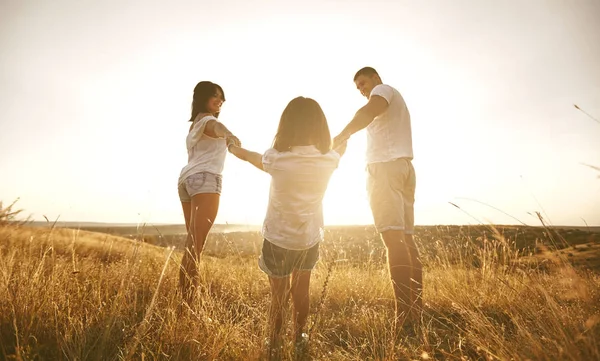 Šťastná rodina na přírodu v létě při západu slunce. — Stock fotografie