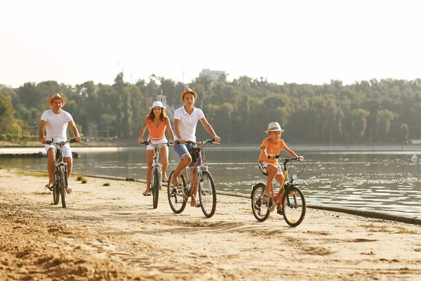 Family riding bicycles on embankment