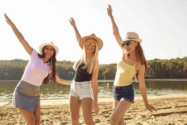 Lekfulla unga kvinnor dansar på stranden — Stockfoto