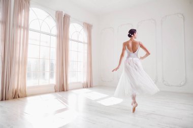 Genç balerin beyaz bir stüdyoda dans