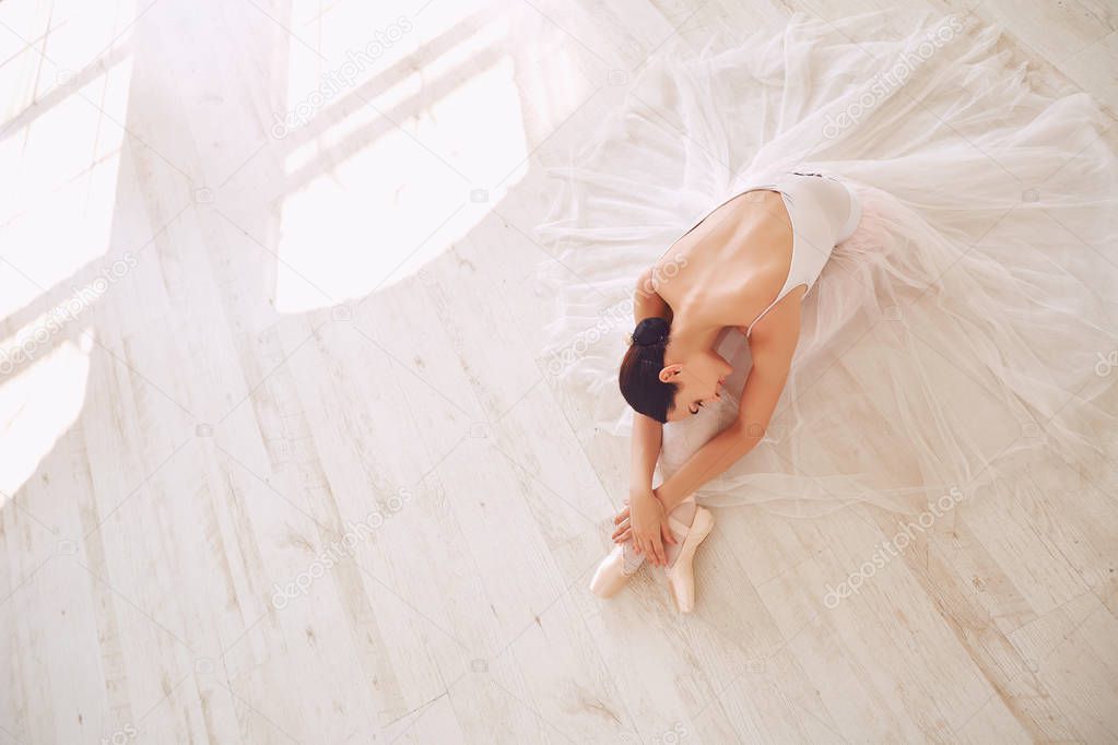 Young ballerina posing on the floor