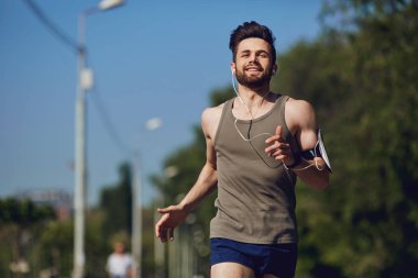 Parka yol boyunca bir erkek atlet çalışır.