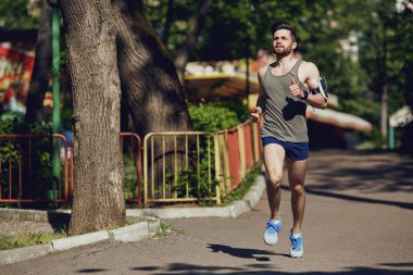 Parka yol boyunca bir erkek atlet çalışır.