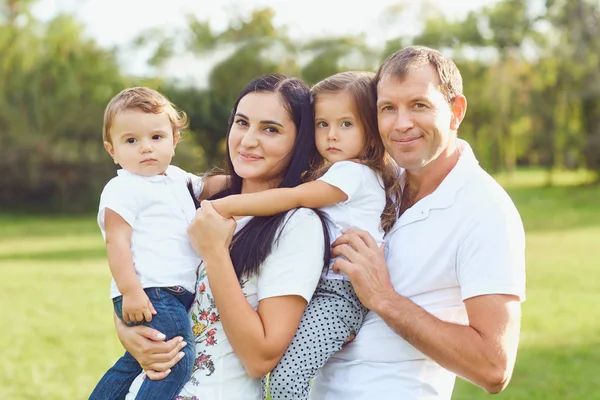 Parkta gülümseyen çocuklu mutlu aile. — Stok fotoğraf