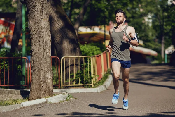Parka yol boyunca bir erkek atlet çalışır.
