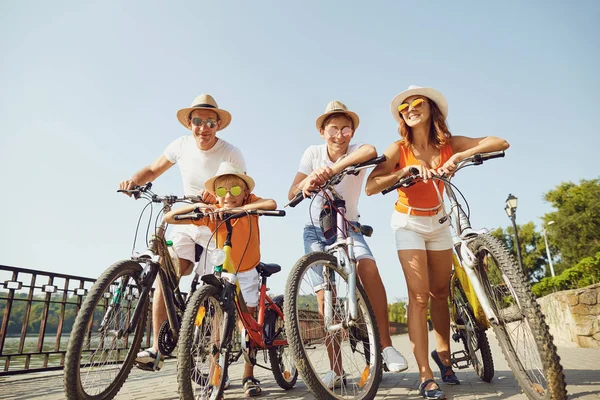 Веселая семья с велосипедами, стоящими на набережной — стоковое фото