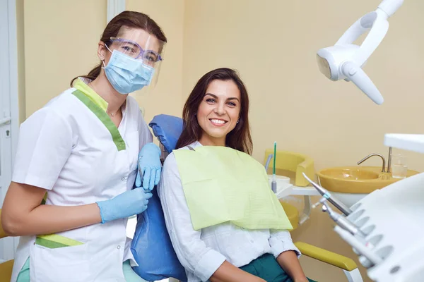 Dentiste et cliente souriant à la clinique dentaire — Photo
