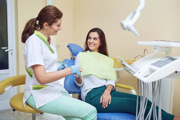 Dentist shakes hands with a woman client in a dental clinic — Stock Photo, Image