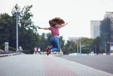 Mutlu kız arkadan görünüm açık havada atlama