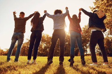 Çayır üzerinde kaldırdı kollarını duran insanlar