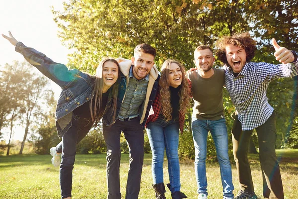 Ungdomar skratta när du står i en park på våren. — Stockfoto