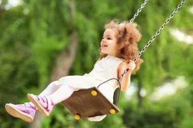 Çocuk oyun park alanında, bir salıncak üzerinde sallanan. 