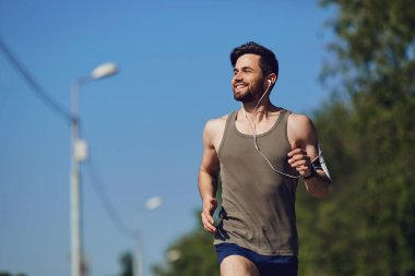 Parka yol boyunca bir erkek atlet çalışır.