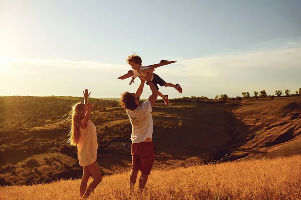 Mutlu aile eğleniyor günbatımında oynarken.