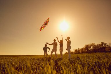 Sahada gün batımında oynayan mutlu bir aile.