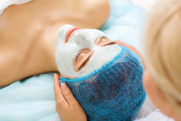 Kosmetolog gör skönhet mask till en ung kvinna. — Stockfoto