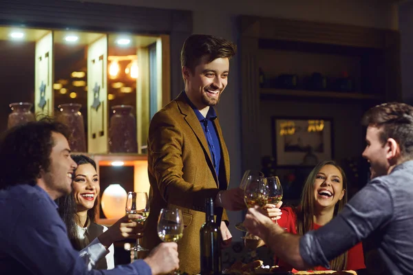 Los amigos se ríen, comen, beben en un restaurante en la cena — Foto de Stock