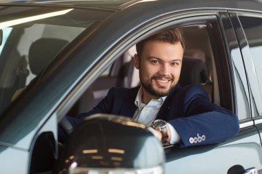 Erkek sürücü arabaya gülümseyen