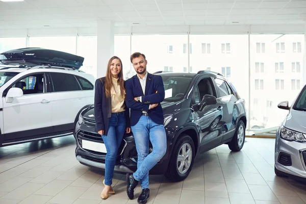 Mladý pár se usmívá na auto showroom — Stock fotografie