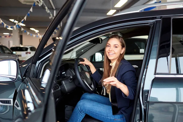 Een vrouwelijke bestuurder glimlacht en houdt van autosleutels. — Stockfoto